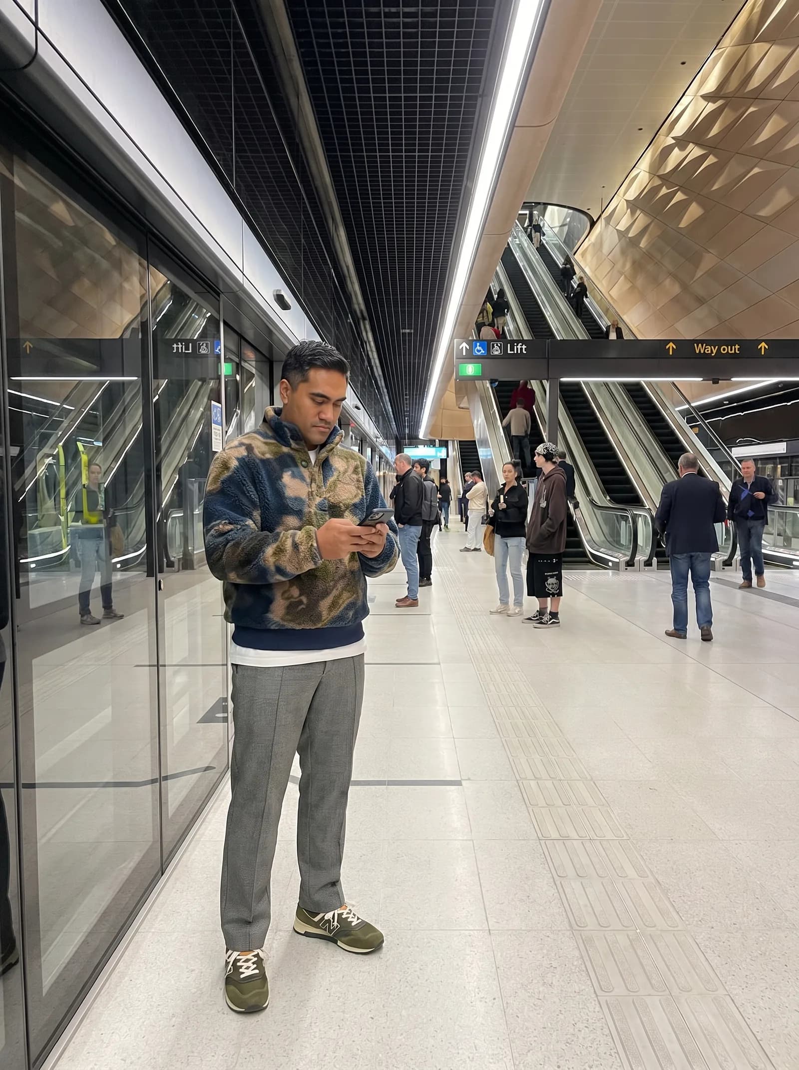 Registrar on a metro platform on the way home, phone in hand